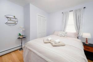 um quarto branco com uma cama com duas toalhas em Convenient Braintree Home - 3 Bedroom Sleeps 8 em Braintree