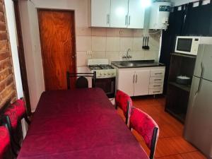 una cocina con una mesa con un mantel rojo. en Complejo Hatun Yaya en Mendoza