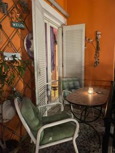 a room with a table and chairs and a table and a window at Pislis Rooms in Kamena Vourla