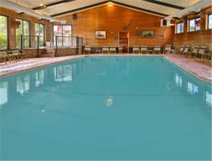 a large swimming pool with blue water in a building at Bavarian Haus Lakefront Inn in Saint Ignace