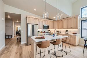 a kitchen with wooden cabinets and a kitchen island with bar stools at Helling Circle Hideaway 303 condo in Heber City