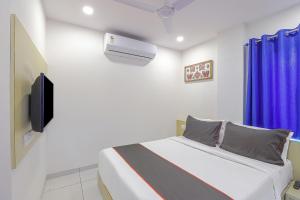 ein Schlafzimmer mit einem Bett und einem TV in der Unterkunft Collection O Hotel La Veera in Ahmedabad
