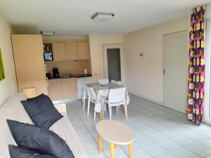 a living room and kitchen with a table and a couch at Appart T3 Terrasse - Piscine - 3 étoiles in Saint-Cyprien