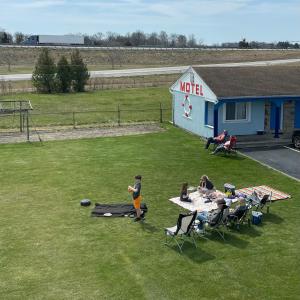 un grupo de personas sentadas en una mesa de picnic en un campo en Best Motel Bowling Green, en Bowling Green