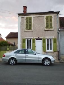 Srebrny samochód zaparkowany przed domem w obiekcie Chambre agréable au fond du jardin w mieście Sancoins