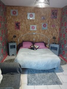 sypialnia z dużym łóżkiem z różowymi poduszkami w obiekcie Chambre agréable au fond du jardin w mieście Sancoins