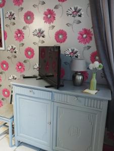 Pokój z niebieską szafką z kwiatami na ścianie w obiekcie Chambre agréable au fond du jardin w mieście Sancoins