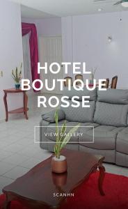 Hotel Boutique Rosse في سان بيدرو سولا: غرفة معيشة مع أريكة وطاولة قهوة