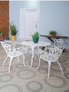 Hotel Boutique Rosse في سان بيدرو سولا: طاولة بيضاء وكراسي في فناء به نباتات