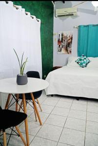 1 dormitorio con 1 cama, mesa y sillas en Hotel Boutique Rosse, en San Pedro Sula
