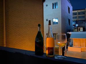 ソウルにあるStay Midcenturyのワイン2本、テーブルの上にグラス1杯