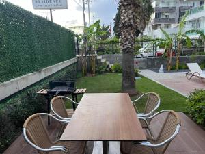 a wooden table and two chairs and a tree at Ulu Panorama Residence in Alanya