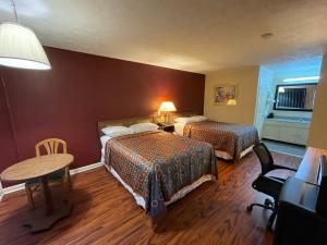 a hotel room with two beds and a table at AMERICAN INN Stevenson in Stevenson