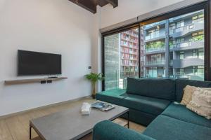 a living room with a green couch and a tv at Al Amine - 202, 1-BR in Mar Mikhael in Beirut