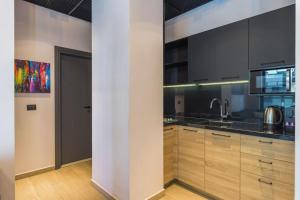 a kitchen with wooden cabinets and black appliances at Al Amine - 202, 1-BR in Mar Mikhael in Beirut