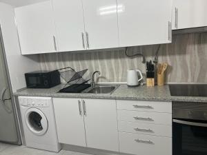 een keuken met een wastafel en een wasmachine bij Apartamento Sunny in Albufeira