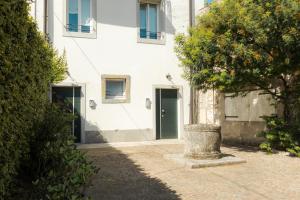 ein weißes Gebäude mit grüner Tür auf einer Straße in der Unterkunft In pieno CENTRO storico con PARCHEGGIO gratuito incluso. in Udine