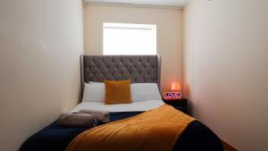 - une chambre avec un lit et une couverture orange dans l'établissement The StayLuxe Apartment Manchester, à Manchester