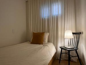 ソウルにあるStay Midcenturyのベッドルーム1室(ベッド1台、ランプ、窓付)