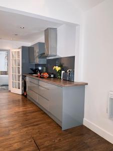 a kitchen with stainless steel appliances and wood floors at The Hideout in Gillingham