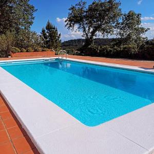 - une piscine d'eau bleue dans une maison dans l'établissement Fátima-Ourém - Quinta da Luz - breakfast included, à Ourém