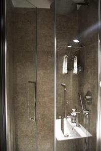 uma casa de banho com um chuveiro, um lavatório e um espelho. em Principe Guesthouse powered by Joyful Guesthouse em Roma