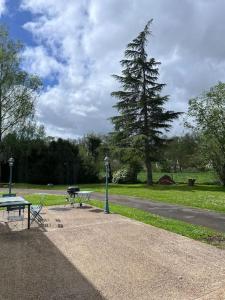 un parque con un banco, una mesa de picnic y un árbol en Studio aux abords des étangs en Milly-sur-Thérain