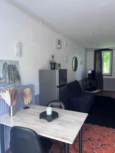 Habitación con mesa, sillas y sala de estar. en Studio aux abords des étangs en Milly-sur-Thérain