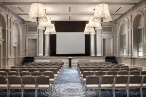una sala de conferencias vacía con una pantalla y sillas en Le Meridien Philadelphia, en Filadelfia