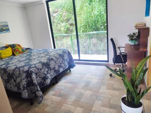 a bedroom with a bed and a large window at Paradise in Envigado- in Envigado