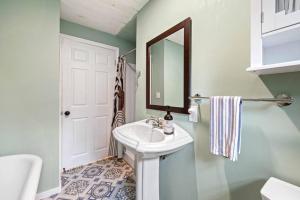 Baño blanco con lavabo y espejo en Cute Cabin in the Woods, en Surry