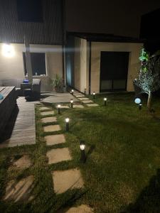 - un jardin avec des lumières sur l'herbe la nuit dans l'établissement Great Room 29, à Mérignac