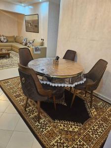 a dining room table with chairs and a living room at view apartments larache in Larache