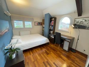 a bedroom with a bed and a desk with a computer at Belle Villa avec Piscine proche de Genève in Veigy-Foncenex