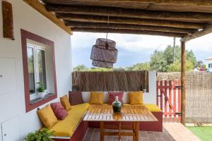 un patio con un sofá amarillo y una mesa en Sunrise Monsaraz - Telheiro e Jardim - 4 pessoas, en Monsaraz