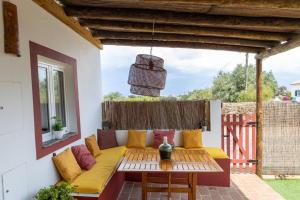 a patio with a yellow couch and a table at Sunrise Monsaraz - Telheiro e Jardim - 4 pessoas in Monsaraz +32 photos
