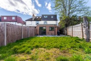 a house with a fence and a yard at Beautiful Wembley Gem - Parking -Sleeps 14 in London