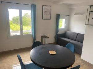 una sala de estar con una mesa y un sofá en Studio vue mer Presqu'ile de Giens (Porquerolles - Var), en Hyères