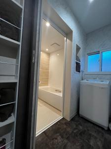 ein Badezimmer mit einer Dusche, einem Waschbecken und einer Badewanne in der Unterkunft 貸し切りゲストハウスsai2nd in Yasugi