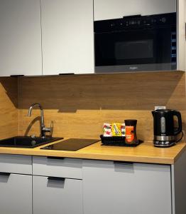 a kitchen counter with a sink and a microwave at Studio przy Rynku - self check in in Opole