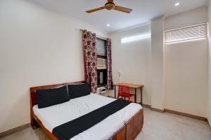 a bedroom with a bed and a ceiling fan at Super OYO OM SAI RAM GUEST HOUSE in Gurgaon