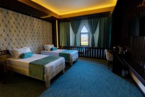 una camera d'albergo con due letti e una finestra di Dashli Qala Hotel a Ganja