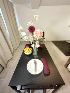 una mesa con un plato de fruta y flores. en Villa Pichon, en Choisy-le-Roi