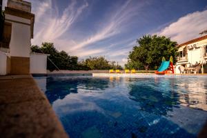 una piscina con tobogán y un parque infantil en Casa Do Ginjal by NaturAlegre en Marvão