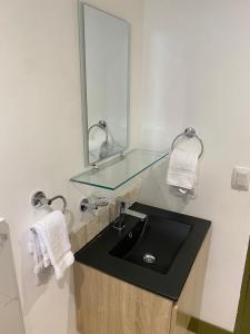 W łazience znajduje się szklana umywalka i lustro. w obiekcie Better Life Mountain Camp Monte Verde w mieście Monteverde