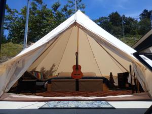 a white tent with a guitar in it at Better Life Mountain Camp Monte Verde in Monteverde Costa Rica