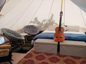 una camera da letto con chitarra in tenda di Better Life Mountain Camp Monte Verde a Monteverde Costa Rica