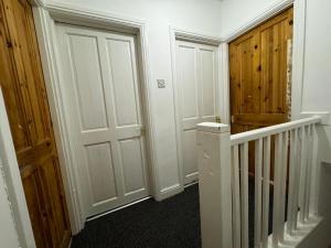 a hallway with a door and a stairway at Deluxe Double Bedroom Manchester in Manchester
