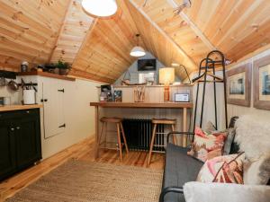 ein Wohnzimmer mit einem Sofa und einer Küche in der Unterkunft Woodmans Huts in Haverthwaite