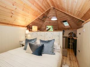 Bett in einem Zimmer mit Holzdecke in der Unterkunft Woodmans Huts in Haverthwaite